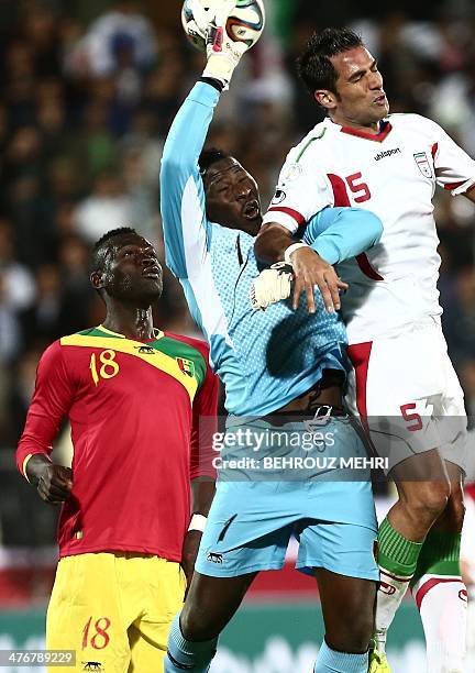 Iran's Amir Hossein Sadeghi vies with Boubacar Fofana and goalkeeper Naby Moussa Yattara of Guinea during their international friendly football match...