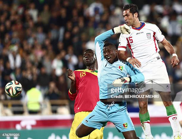 Iran's Amir Hossein Sadeghi vies for the ball with Boubacar Fofana and goalkeeper Naby Moussa Yattara of Guinea during their international friendly...