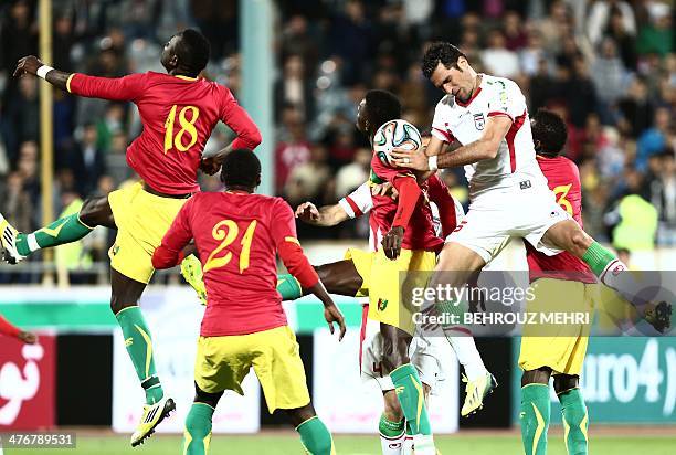 Iran's Amir Hossein Sadeghi vies for the ball with Boubacar Fofana and Djibril Tamsir Paye of Guinea during their international friendly football...