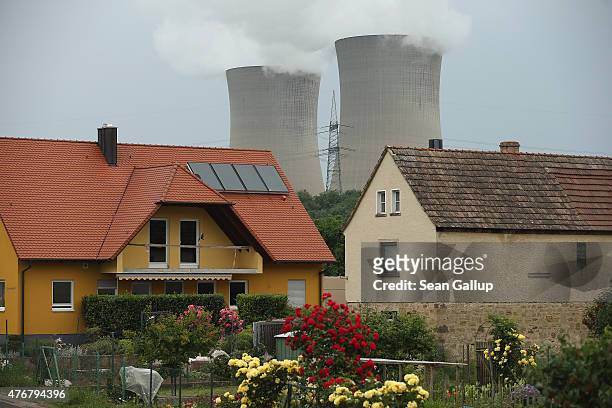 Steam rises from the cooling towers of the Grafenrheinfeld nuclear power plant near residential houses on June 11, 2015 in Garstadt, Germany. The...