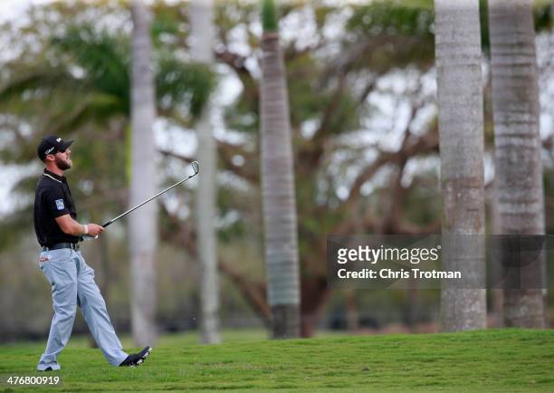 Graham DeLaet of Canada watches a shot during a practice round prior to the start of the World Golf Championships-Cadillac Championship at Trump...