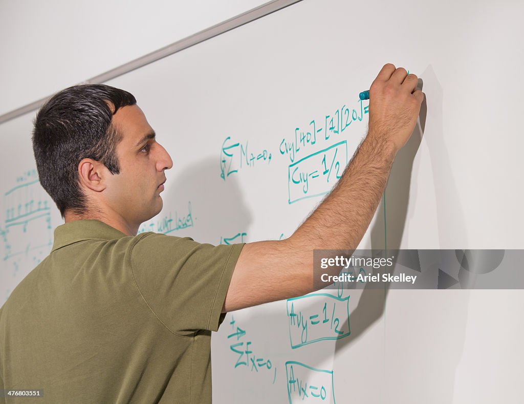 Asian man writing on whiteboard