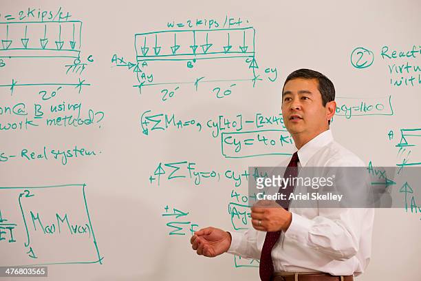 japanese teacher standing in front of whiteboard - lecturer whiteboard stock pictures, royalty-free photos & images