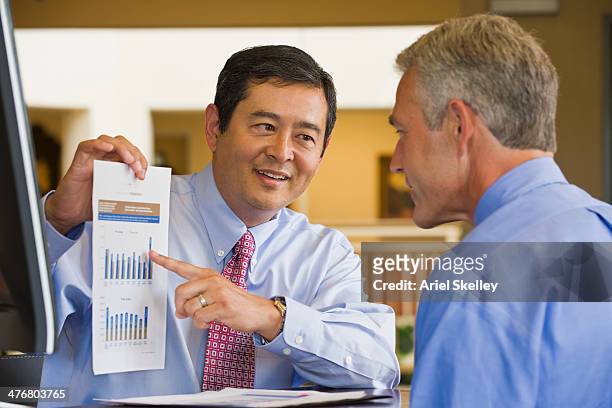 businessman showing chart to co-worker - customer profile stock pictures, royalty-free photos & images