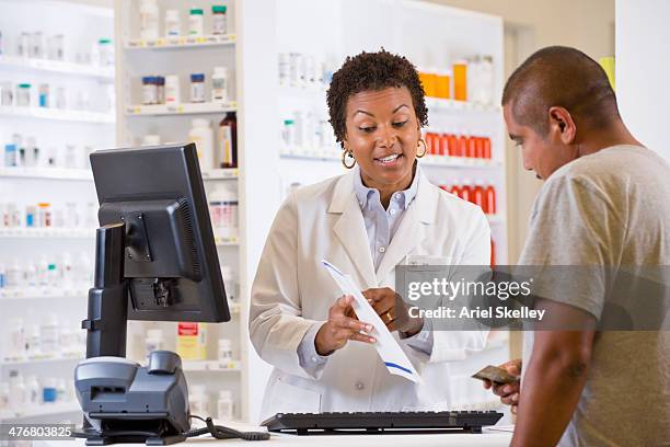 customer talking to pharmacist - black pharmacist stock pictures, royalty-free photos & images