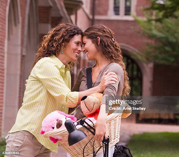 mixed race mother saying goodbye to daughter going to college - basket universitario imagens e fotografias de stock