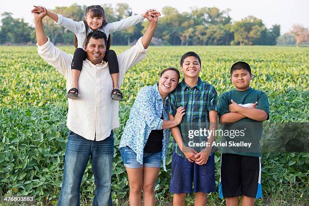 hispanic family smiling in crop field - migrant farmers fotografías e imágenes de stock