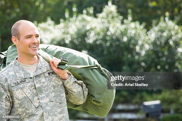 caucasian soldier carrying duffel bag outdoors - military uniform stock pictures, royalty-free photos & images