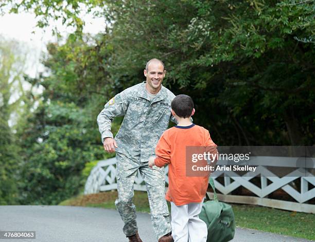 caucasian returning soldier greeting son - fallen heroes stock pictures, royalty-free photos & images