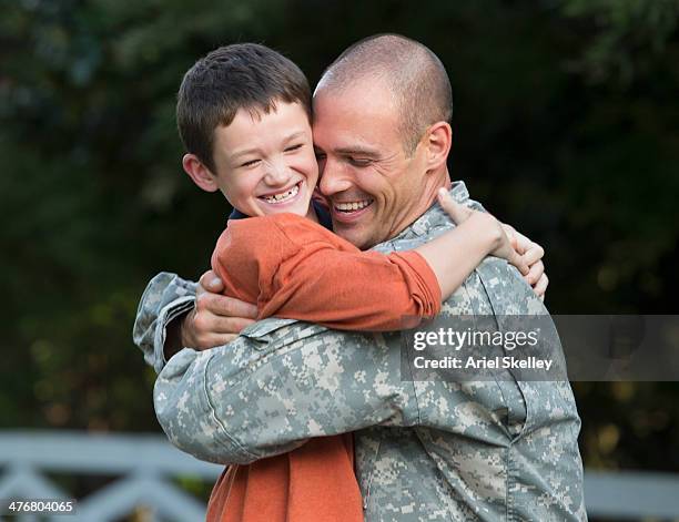 caucasian returning soldier greeting son - homecoming foto e immagini stock