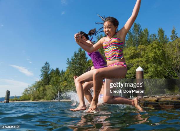 girls jumping together into lake - lake whatcom bildbanksfoton och bilder
