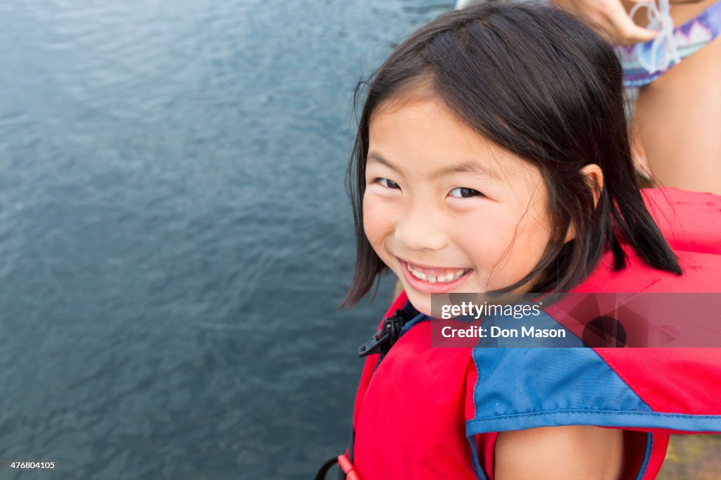 Mixed race girl smiling by lake