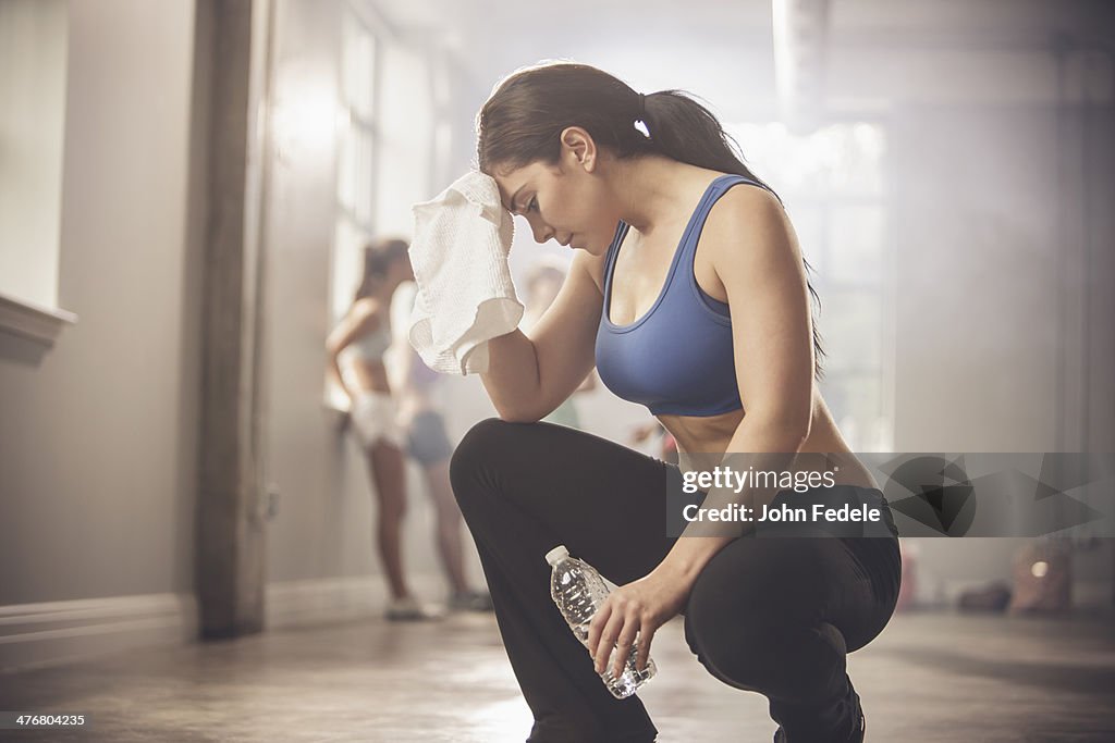 Woman wiping sweat with towel in gym