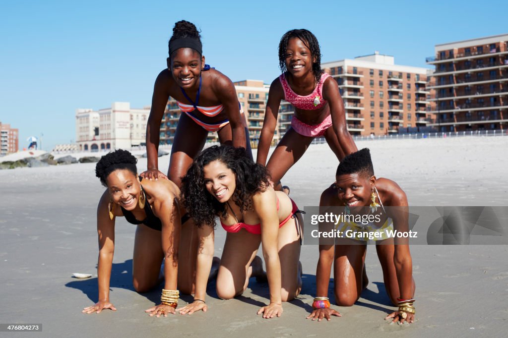 Women forming pyramid on beach