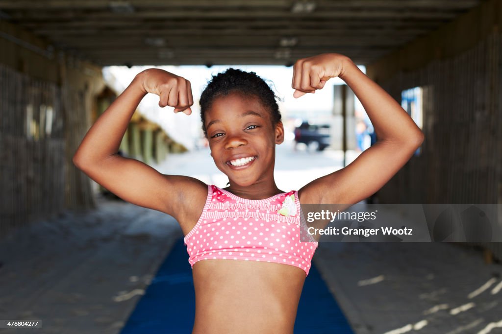 Black girl flexing muscles outdoors