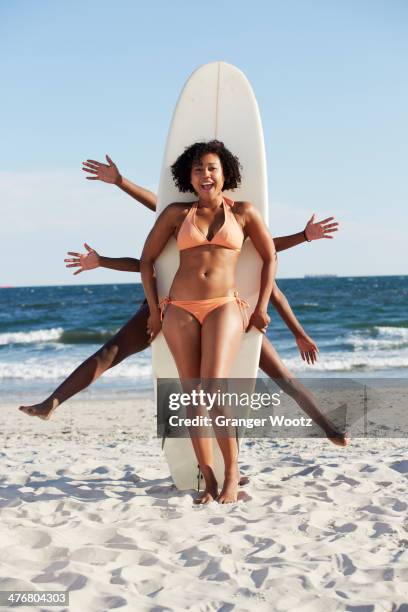friends posing with surfboard on beach - maillot de bain photos et images de collection