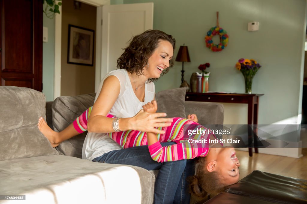 Mother and daughter playing in living room