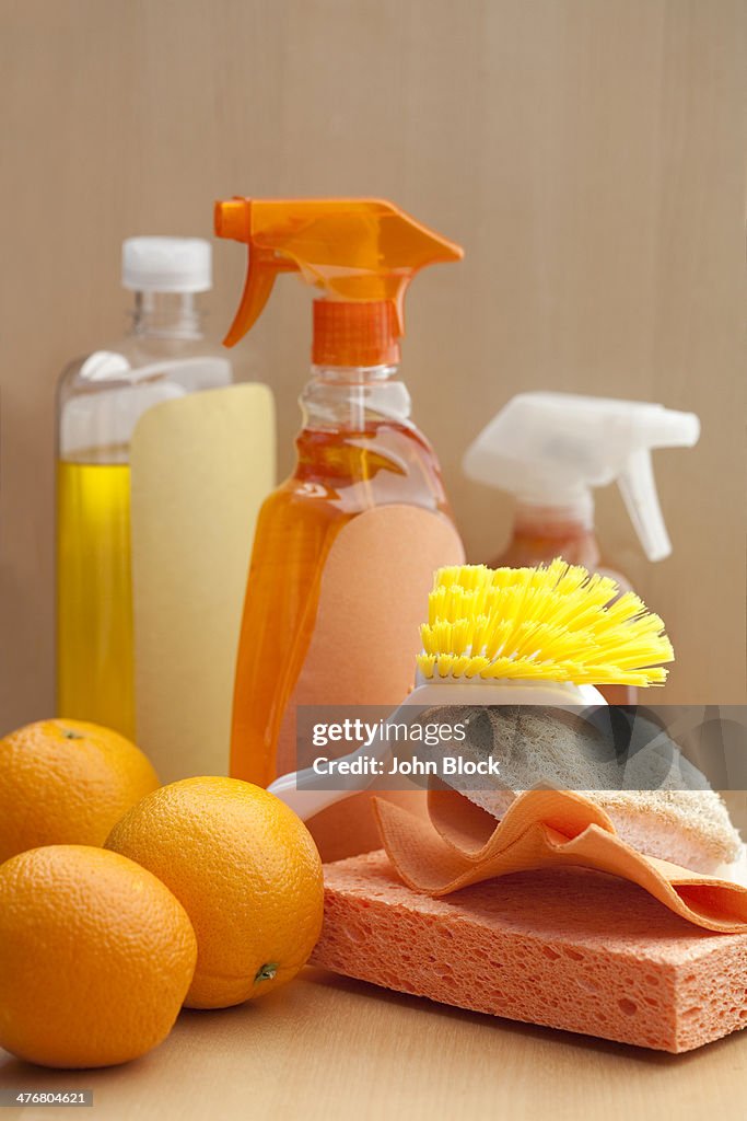 Spray bottles, sponge, scrubber and oranges