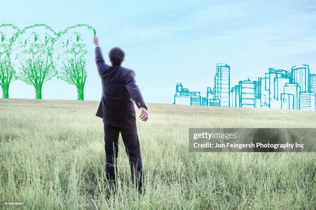 Indian businessman drawing trees on sky