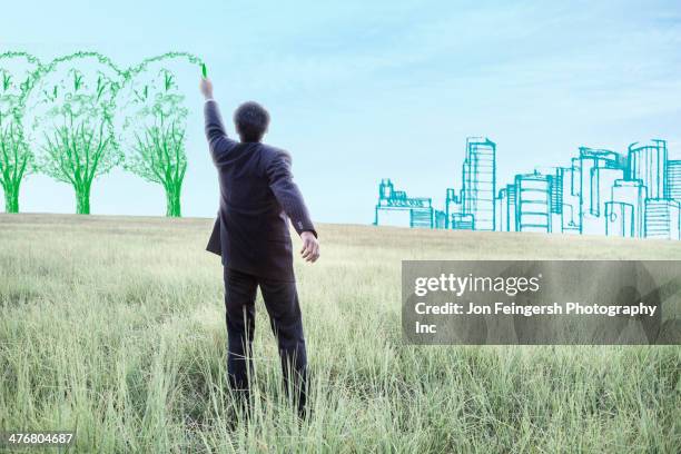 indian businessman drawing trees on sky - corporate social responsibility stock-fotos und bilder