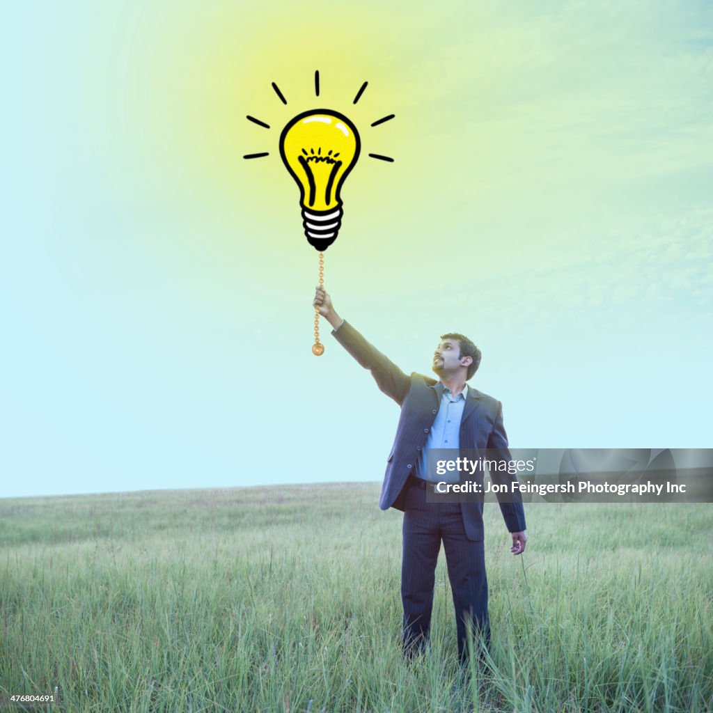 Indian businessman pulling chain on light bulb illustration