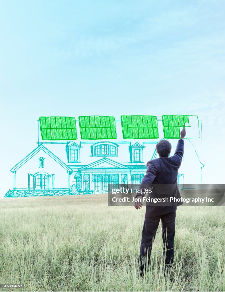 Indian businessman drawing solar panels on home