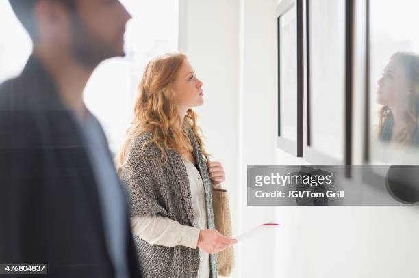 woman admiring art in gallery - exhibition foto e immagini stock