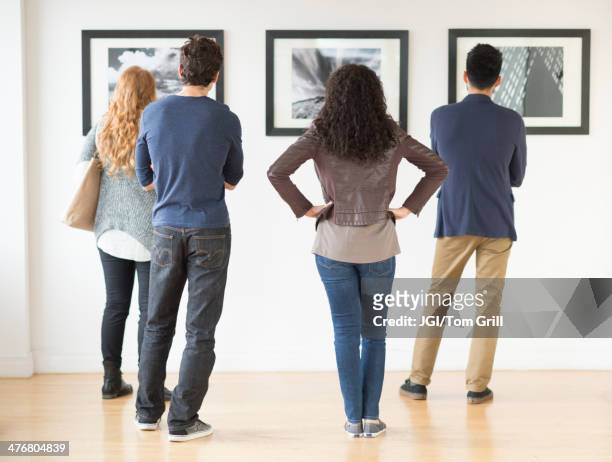 couples admiring art in gallery - rear view stock pictures, royalty-free photos & images