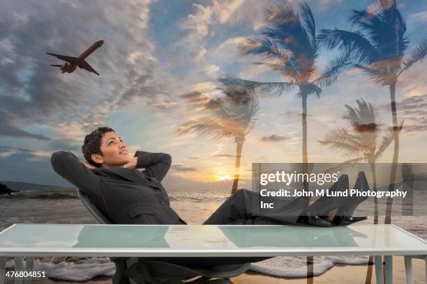 mixed race businesswoman imagining tropical beach - escaping office stock pictures, royalty-free photos & images