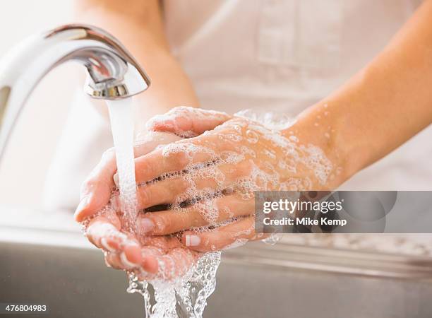 caucasian woman washing her hands - lavar imagens e fotografias de stock