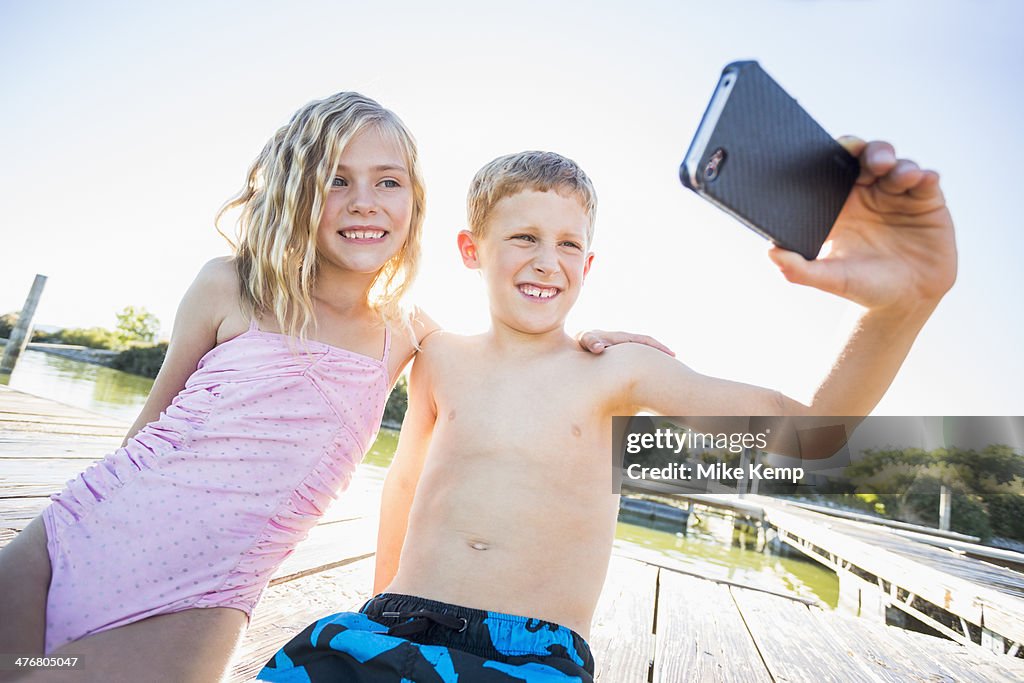 Caucasian children taking selfie with cell phone