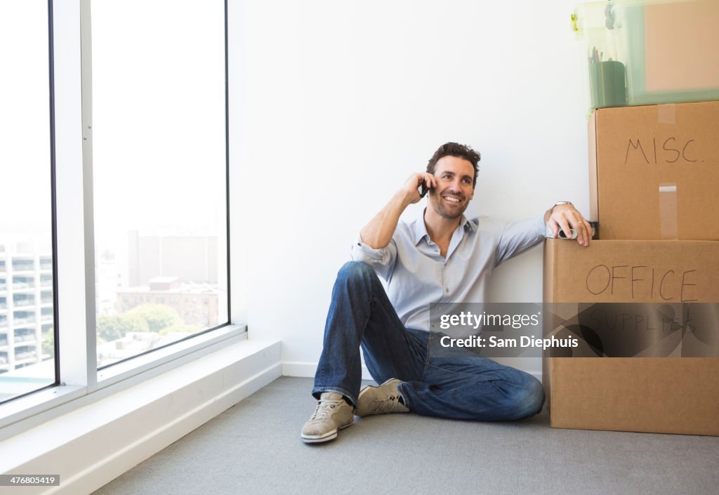 Hispanic businessman on cell phone in new office