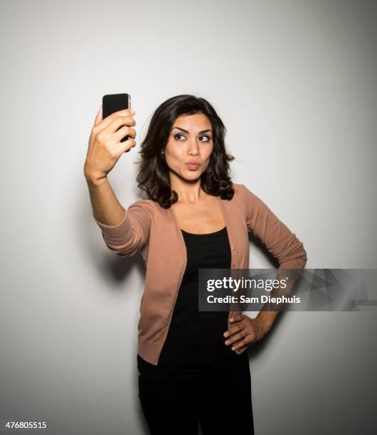 mixed race businesswoman taking cell phone picture - duck face photos et images de collection