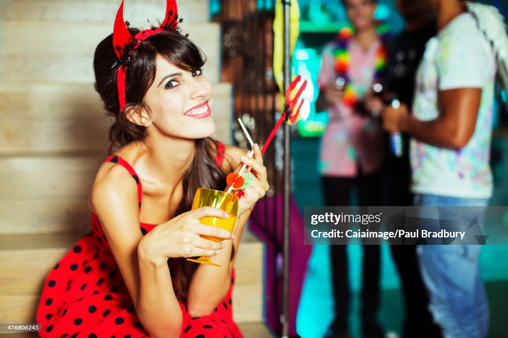 Woman wearing devil costume at party