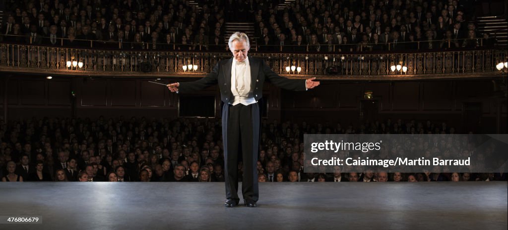 Conductor performing on stage in theater