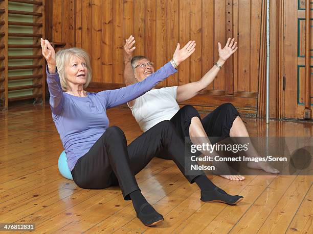 women practicing yoga together in studio - sports venue stock pictures, royalty-free photos & images