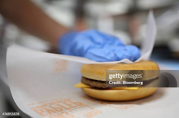 An employee wraps a freshly made cheeseburger in the kitchen at McDonald's Corp.'s 505th Russian fast food restaurant on its opening day at the...