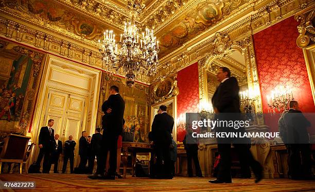 Delegation members wait outside the meeting room where foreign ministers, including Russian Foreign Minister and his US counterpart, were discussing...