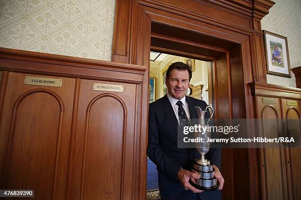 Sir Nick Faldo, golfer and three times winner of the Open Championship, with his Open Championship winner's Claret Jug, stands beside his locker in...