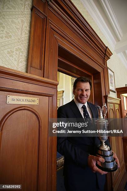 Sir Nick Faldo, golfer and three times winner of the Open Championship, with his Open Championship winner's Claret Jug, stands beside his locker in...