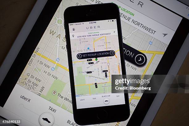 The Uber Technologies Inc. Application is displayed on an Apple Inc. IPhone 5s and iPad Air in this arranged photograph in Washington, D.C., U.S., on...