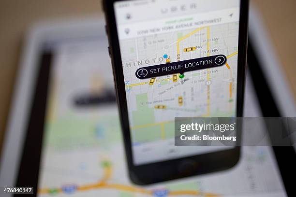 The Uber Technologies Inc. Application is displayed on an Apple Inc. IPhone 5s and iPad Air in this arranged photograph in Washington, D.C., U.S., on...