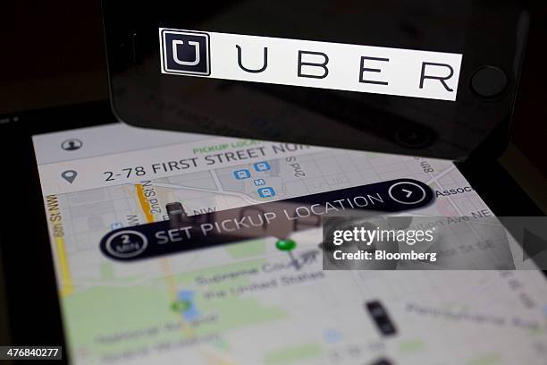 The Uber Technologies Inc. Application and logo are displayed on an Apple Inc. IPhone 5s and iPad Air in this arranged photograph in Washington,...