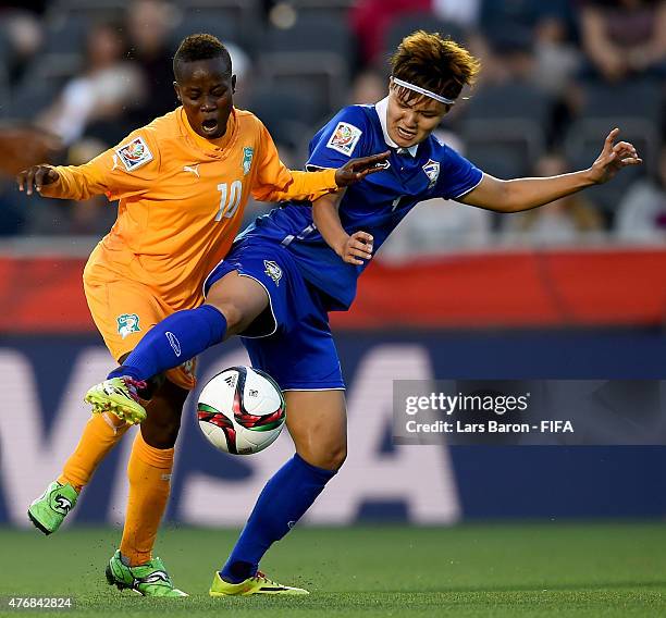 Ange Nguessan of Cote D'Ivoire is challenged by Natthakarn Chinwong of Thailand during the FIFA Women's World Cup 2015 Group B match between Cote...