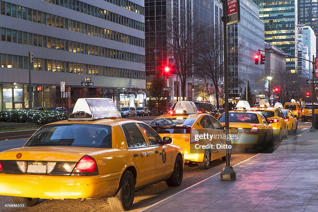 Row of yellow cabs next to sidewalk, New York, USA