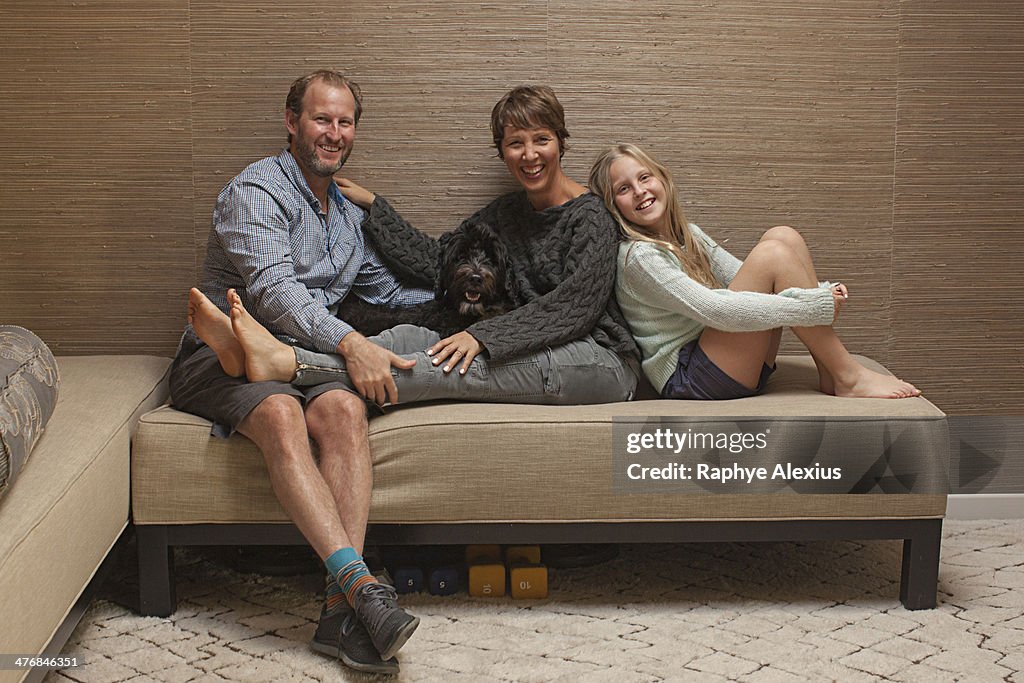 Portrait of parents and daughter on sofa