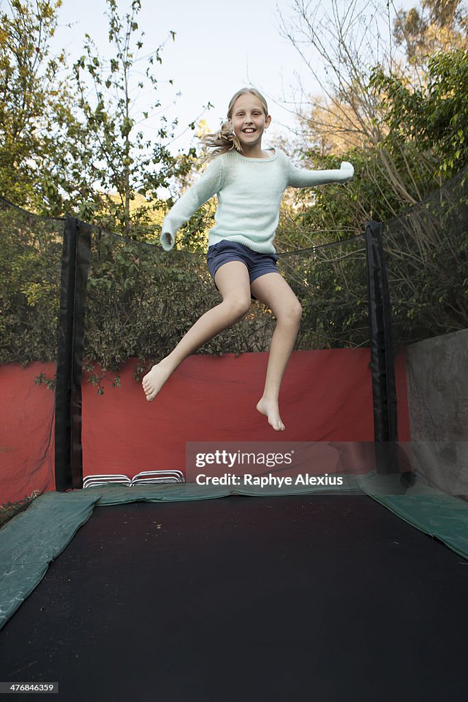Girl having fun on garden trampoline