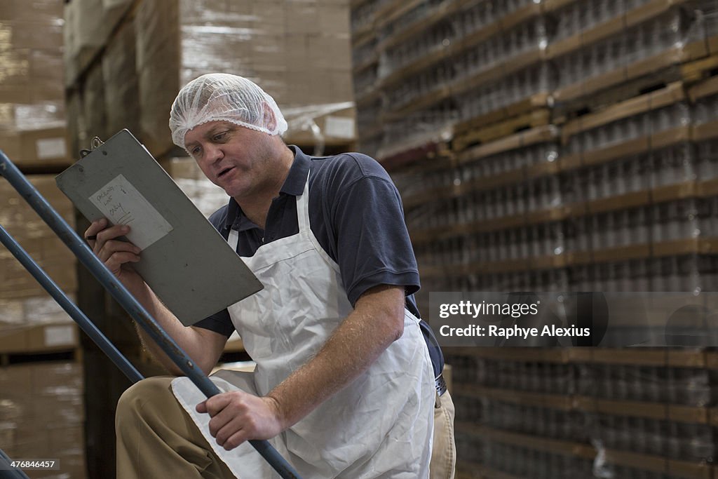 Man holding clipboard in warehouse