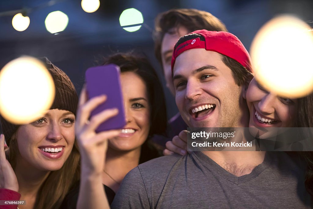 Young adult friends taking selfie at party