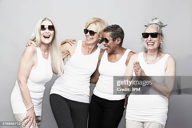 studio portrait of senior women friends in sunglasses - vier freunde stock-fotos und bilder